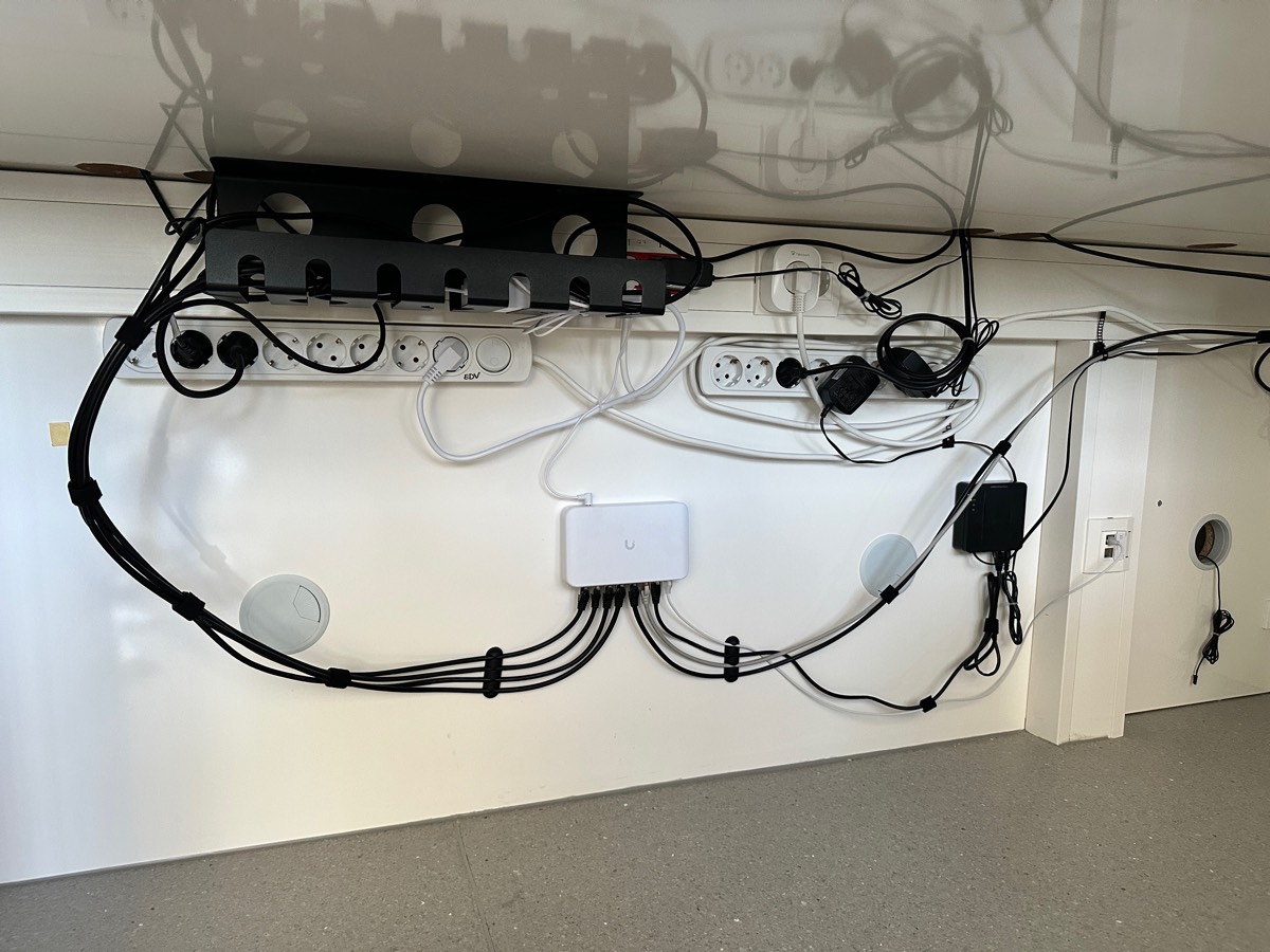 Nachher: dieselbe Anmeldung. UniFi Switch an der Wand, Netzteile in der Kabelwanne, jedes Kabel gebündelt und geführt.